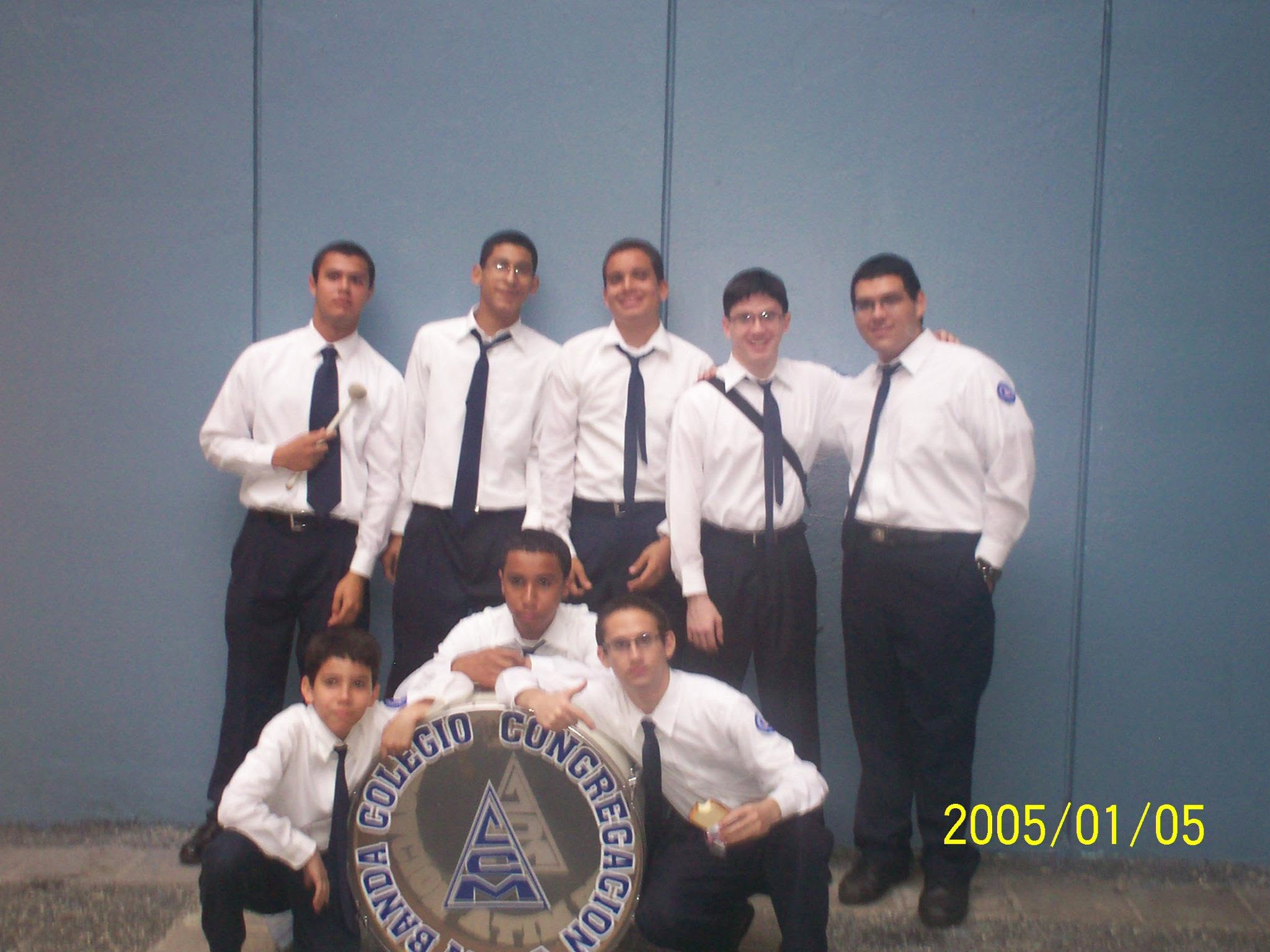 Percussion section members posing together with their concert band bass drum