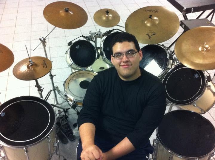 A younger Peter Rodriguez seated behind a large drum kit