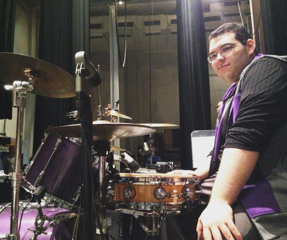 Peter Rodriguez seated at a drum kit during an earlier performance